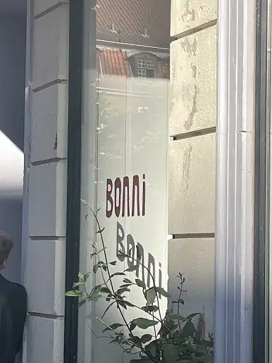 Bonni-logoet trykt på et butiksvindue i sollys.